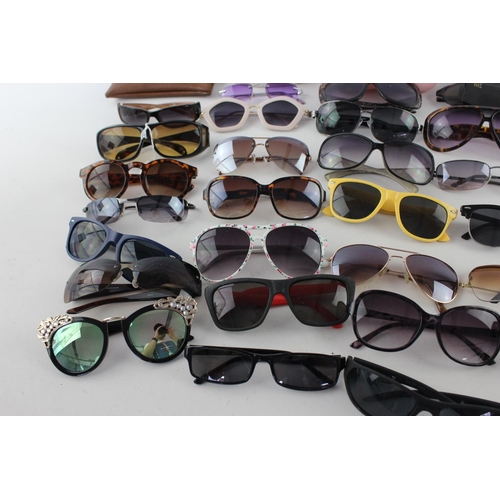 717 - A large collection of assorted pairs of sunglasses to include DKNY, Foster Gant, Oasis etc.