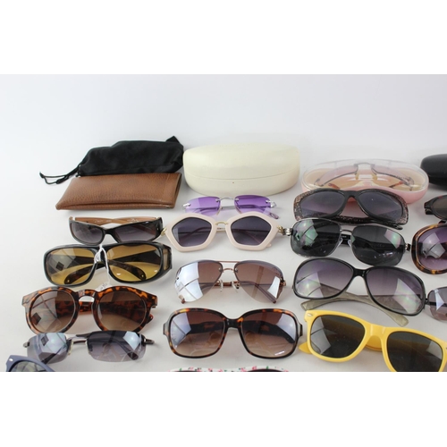 717 - A large collection of assorted pairs of sunglasses to include DKNY, Foster Gant, Oasis etc.