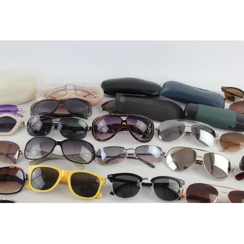 717 - A large collection of assorted pairs of sunglasses to include DKNY, Foster Gant, Oasis etc.