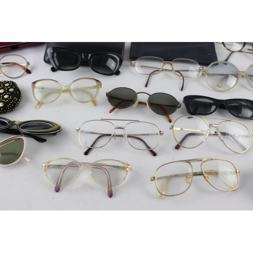 719 - A collection of assorted pairs of vintage sunglasses and spectacles to include Polaroid, 70's etc.