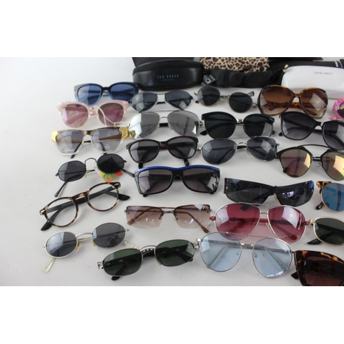 754 - A large collection of assorted pairs of sunglasses to include DKNY, Ted Baker, Nine West etc.