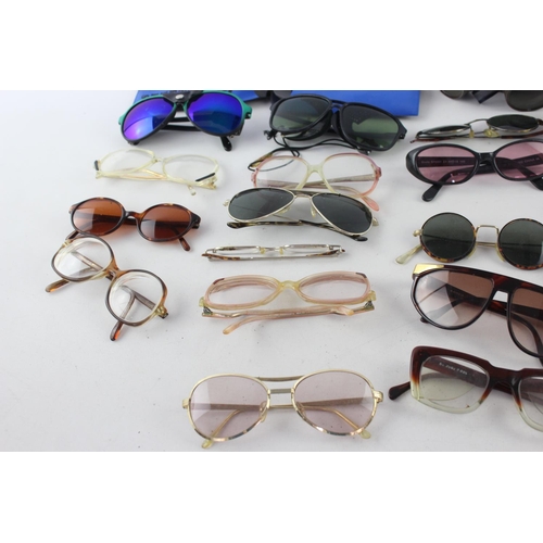 756 - A collection of assorted pairs of vintage sunglasses and spectacles to include Polaroid, 70's etc.