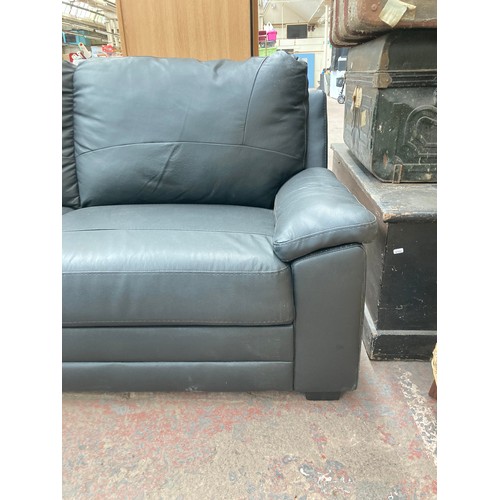 1155 - A modern black leatherette two seater sofa - approx. 85cm high x 175cm wide x 80cm deep