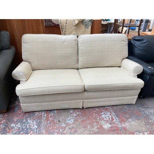 1154A - A modern cream upholstered two seater sofa