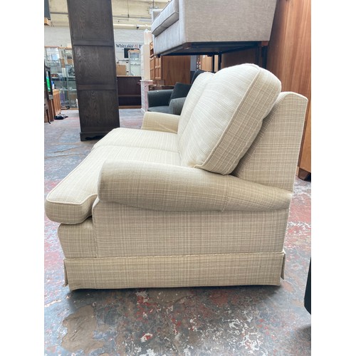 1154A - A modern cream upholstered two seater sofa