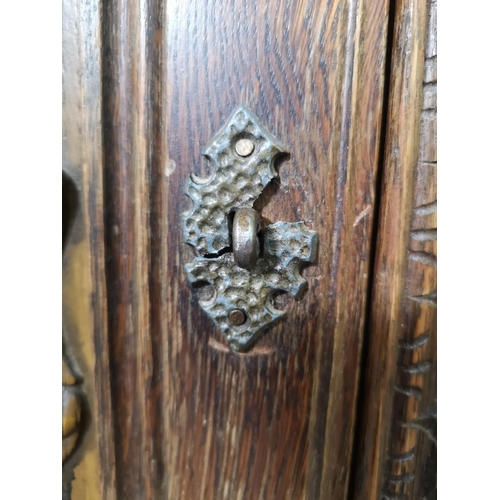 1141B - A 17th century style carved oak side cabinet with two cupboard doors and two lower drawers - approx.... 