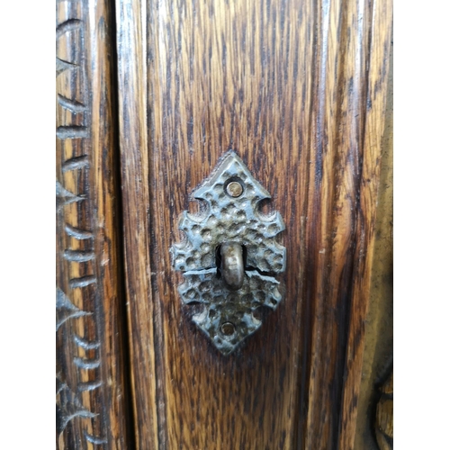 1141B - A 17th century style carved oak side cabinet with two cupboard doors and two lower drawers - approx.... 