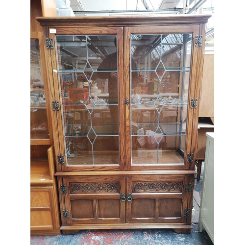 1162 - An Old Charm oak display cabinet with two upper leaded glass doors, two lower cupboard doors and thr... 