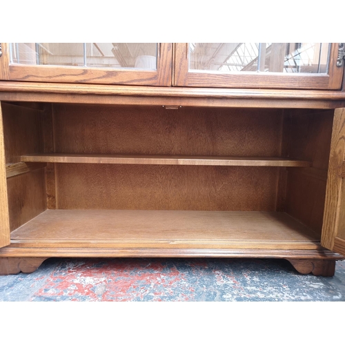 1162 - An Old Charm oak display cabinet with two upper leaded glass doors, two lower cupboard doors and thr... 