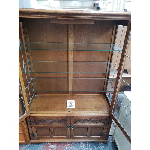 1162 - An Old Charm oak display cabinet with two upper leaded glass doors, two lower cupboard doors and thr... 