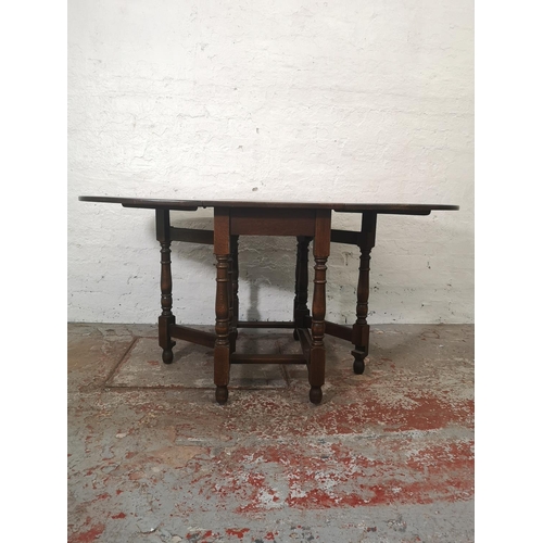 1165 - A Jaycee oak drop leaf gate leg dining table with four matching chairs and one smaller matching drop... 