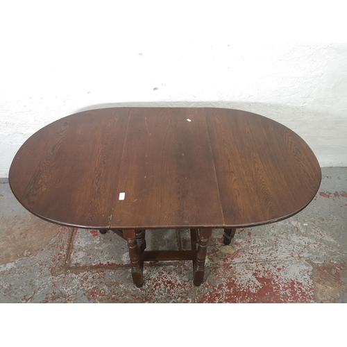 1165 - A Jaycee oak drop leaf gate leg dining table with four matching chairs and one smaller matching drop... 