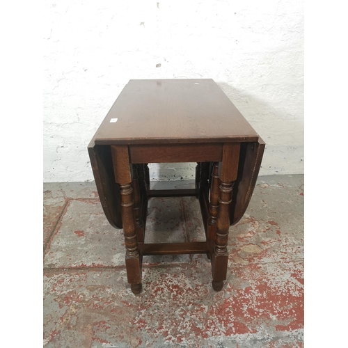 1165 - A Jaycee oak drop leaf gate leg dining table with four matching chairs and one smaller matching drop... 