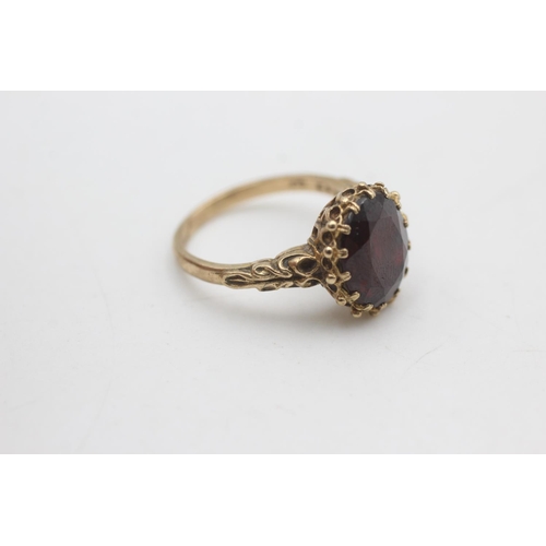 2176 - A 9ct gold oval cut garnet with ornate frame ring, size P - approx. gross weight 4.6 grams