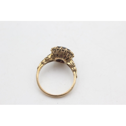 2176 - A 9ct gold oval cut garnet with ornate frame ring, size P - approx. gross weight 4.6 grams