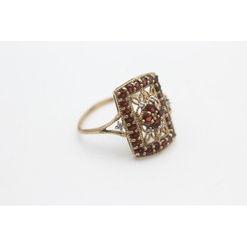 2194 - A 9ct gold garnet and diamond cutwork ring, size U½ - approx. gross weight 3 grams