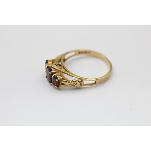 2290 - A hallmarked London 9ct gold three stone garnet ring, size Q½ - approx. gross weight 2.8 grams