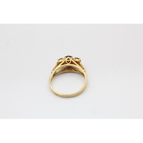 2290 - A hallmarked London 9ct gold three stone garnet ring, size Q½ - approx. gross weight 2.8 grams