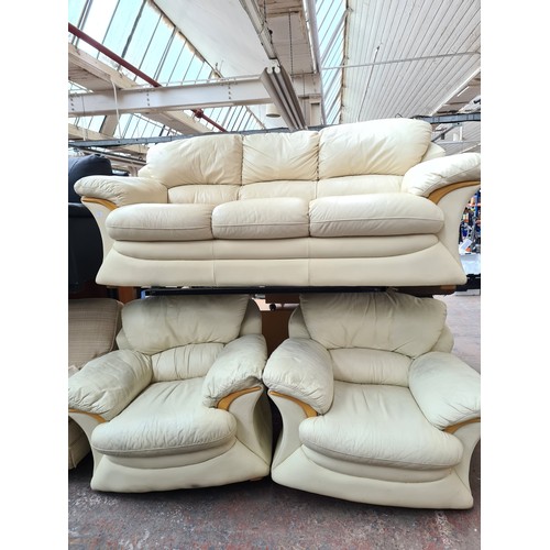 1155B - A modern cream leather and beech three piece lounge suite comprising three seater sofa and two armch... 