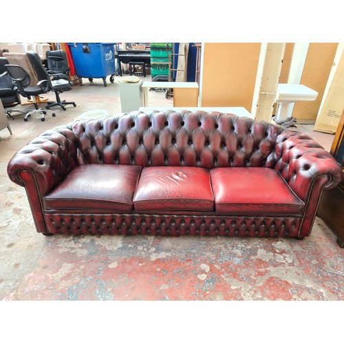 1176A - An oxblood leather chesterfield 3-seater sofa - approx. 83cm high x 238cm wide x 93cm deep