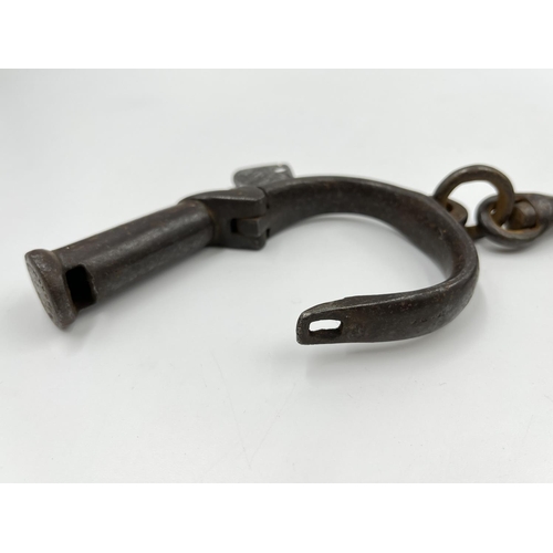 73 - A pair of 19th century wrought iron Hiatt no. 13 Darby non-adjustable handcuffs, having a single loc... 