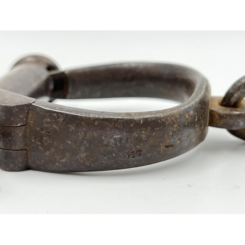 73 - A pair of 19th century wrought iron Hiatt no. 13 Darby non-adjustable handcuffs, having a single loc... 