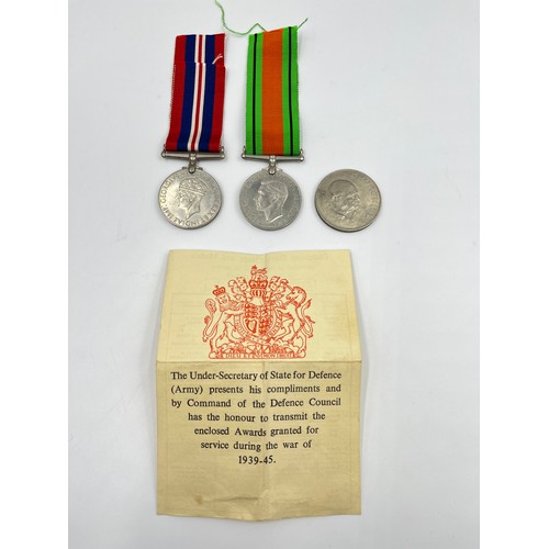 65 - Three items, two WWII British medals, Defence and War with paperwork and ribbons and one 1965 Winsto... 