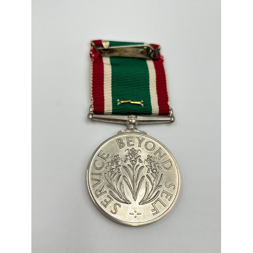 65B - A cased Women's voluntary service medal with certificate and gold plated badge