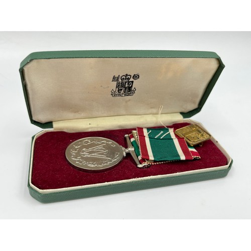 65B - A cased Women's voluntary service medal with certificate and gold plated badge