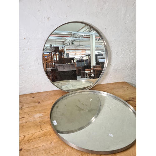 1198 - A pair of industrial style brushed steel framed circular wall mirrors - both approx. 70cm diameter