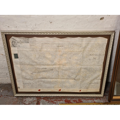 1202 - Three items, one gilt framed bevelled edge mirror and two antique framed indentures - largest approx... 