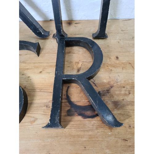 528 - Four vintage black painted aluminium shop display letters - approx. 38cm high