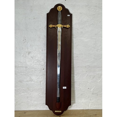 833 - An ornamental King Arthur's Excalibur sword on mahogany plaque - sword approx. 109cm long x 24cm wid... 