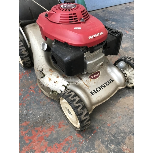 1695 - Two items, one Honda IZY petrol lawn mower and one Bosch ART 25 GSAV electric strimmer