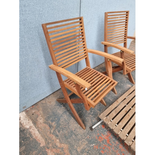 1714 - A wooden three piece garden dining set comprising rectangular table and two chairs