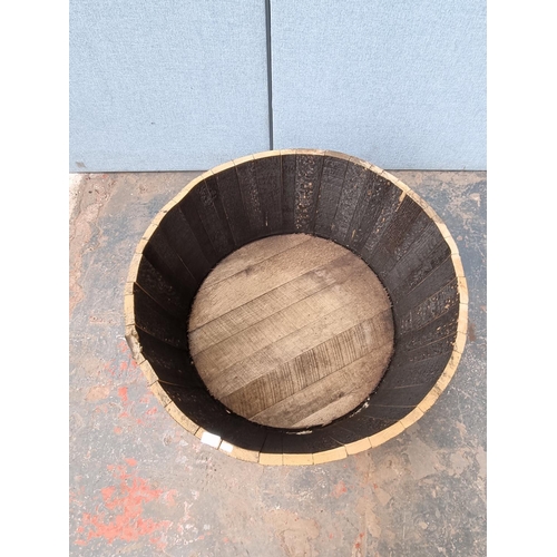 1716 - A wooden and metal banded barrel planter - approx. 43cm high x 90cm diameter