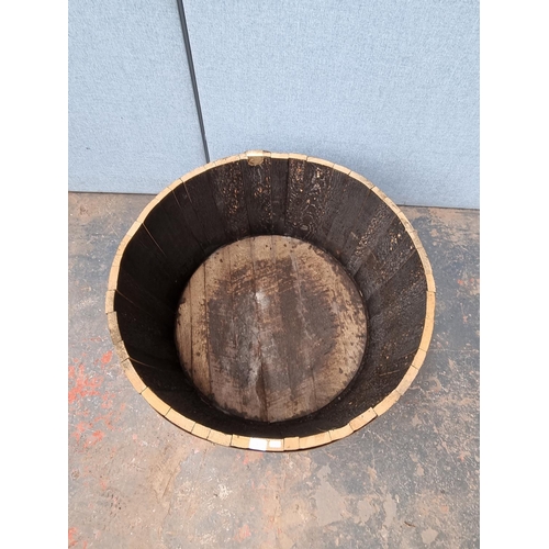 1717 - A wooden and metal banded barrel planter - approx. 43cm high x 90cm diameter