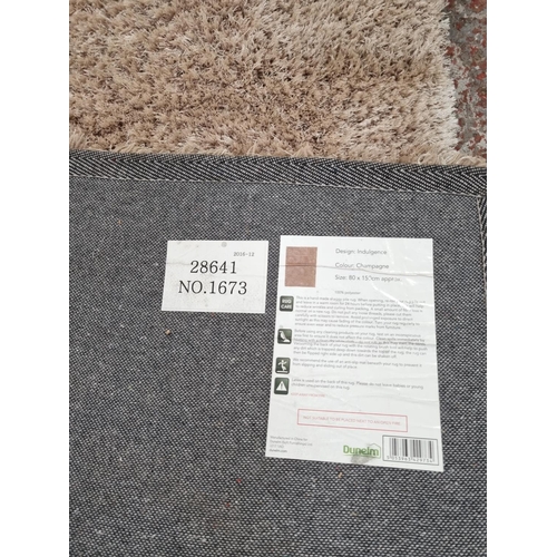 1180B - A Dunelm 'Indulgence' design champagne coloured rug - approx. 80cm x 150cm