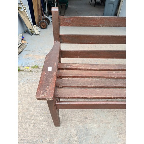 1718 - A brown painted wooden two seater garden bench - approx. 83cm high x 152cm long x 69cm deep