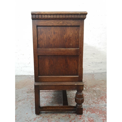 325 - A 17th century style carved oak side cabinet with two cupboard doors and two lower drawers - approx.... 