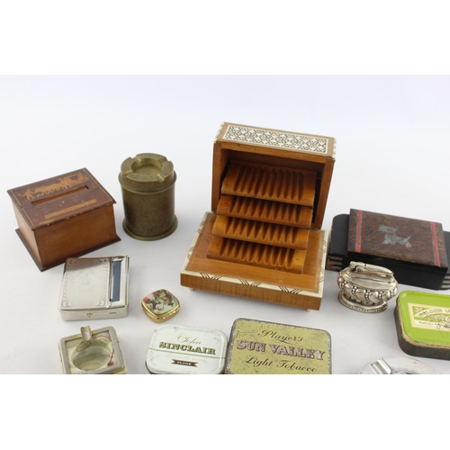 107 - A collection of assorted smoking accessories to include dispenser, tins, ashtrays etc.