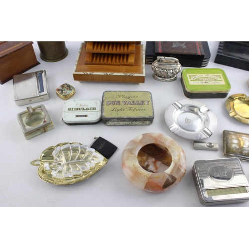 107 - A collection of assorted smoking accessories to include dispenser, tins, ashtrays etc.