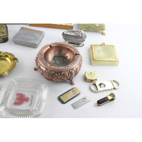 283 - A collection of assorted smoking accessories to include dispenser, tins, ashtrays etc.