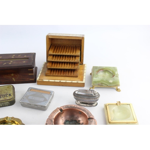 283 - A collection of assorted smoking accessories to include dispenser, tins, ashtrays etc.