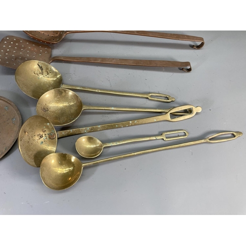 131 - Eight pieces of antique copper and brassware to include fish slice, ladle etc.