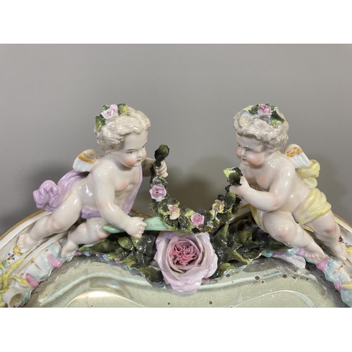 65 - A 19th Meissen style porcelain framed bevelled edge mirror with putti design - approx. 35cm high x 2... 