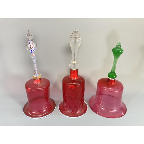 69 - Three late 19th century cranberry glass bells - largest approx. 29cm high