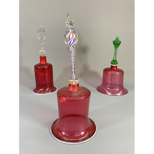 69 - Three late 19th century cranberry glass bells - largest approx. 29cm high