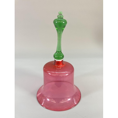 69 - Three late 19th century cranberry glass bells - largest approx. 29cm high