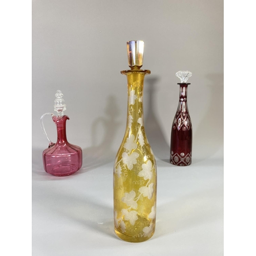 73 - Four coloured glass decanters to include two late 19th century cranberry glass etc.